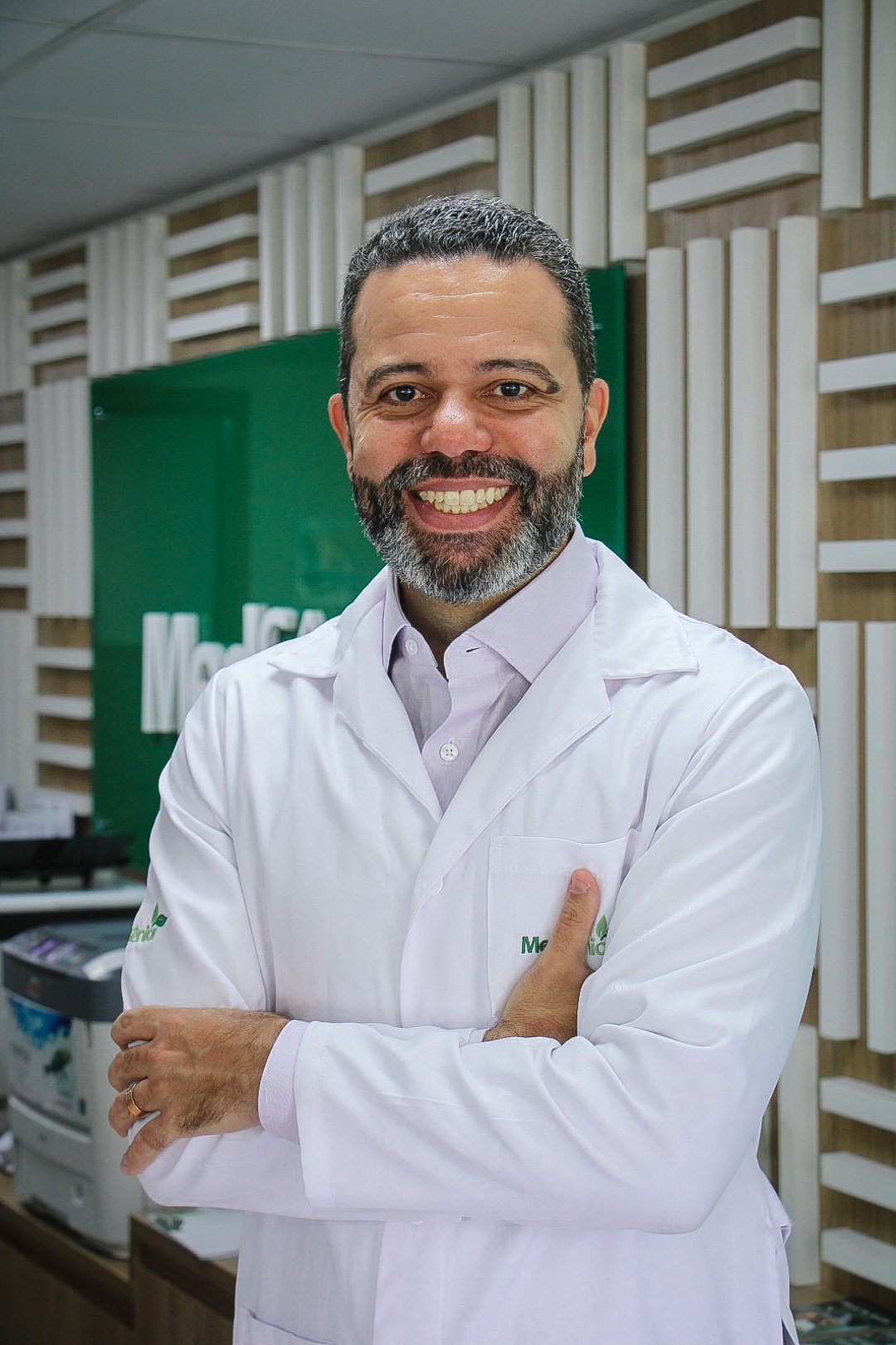 Retrato do Dr. Marcos Adriano Jota, cirurgião oncológico e Gerente Médico Nacional da MedSênior, de jaleco branco